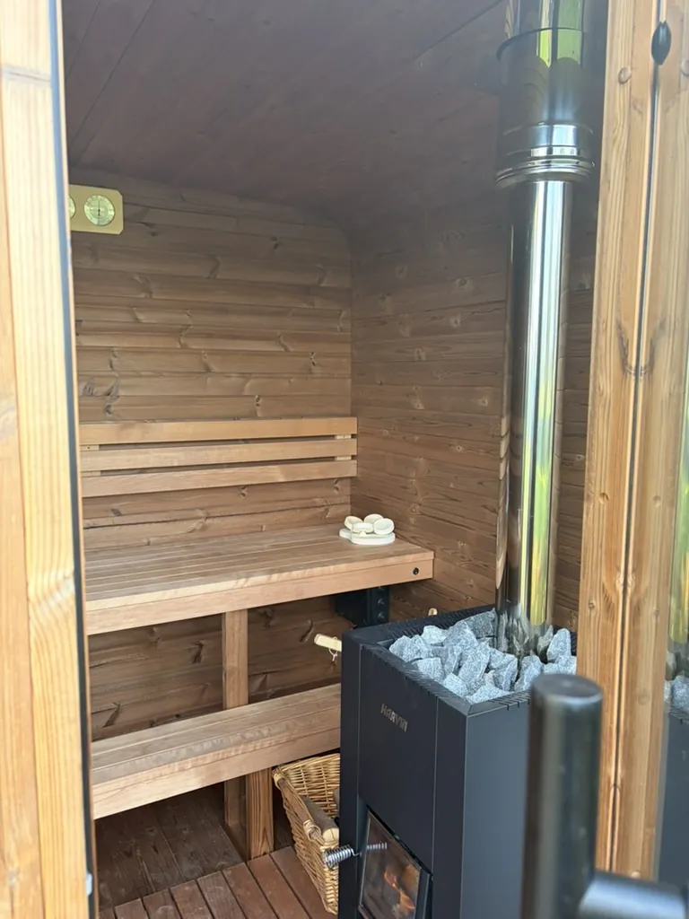 Houten saunabanken en houtkachel in de privésauna