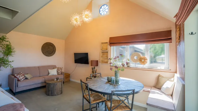 Lichte leefruimte met ronde eettafel en zithoek bij Terra Retreat